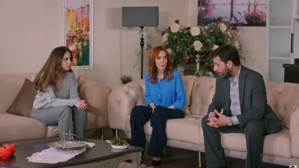 Beyza, Yonca i Nusret siedzą na kanapach w salonie.