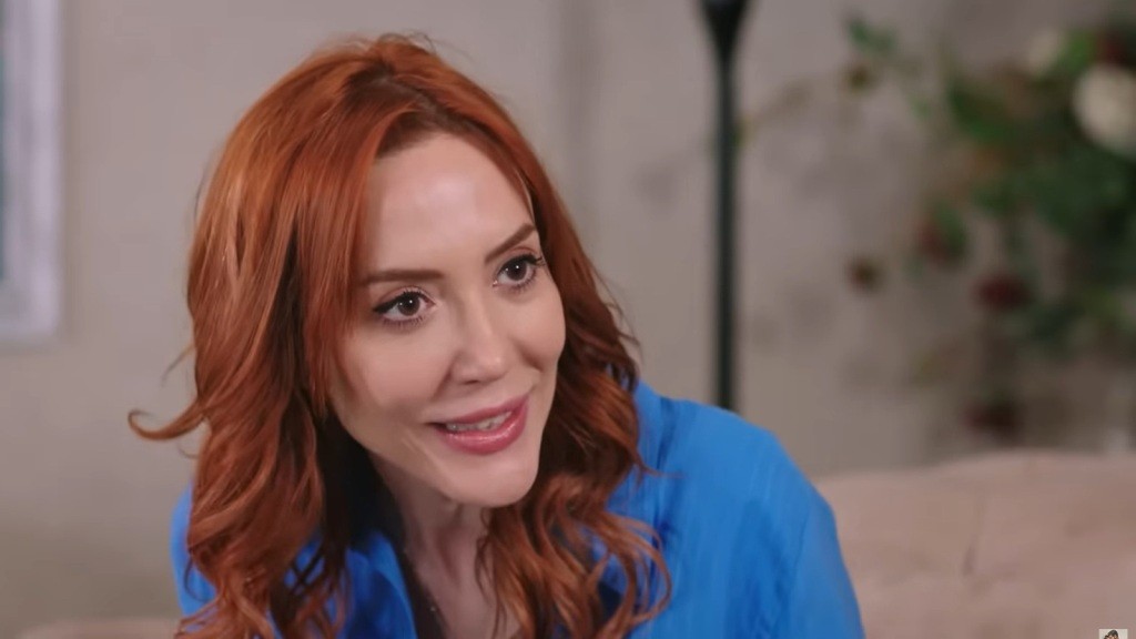 Yonca uśmiecha się z zaskoczeniem.