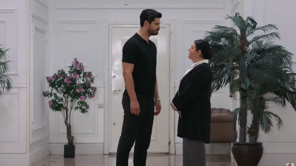 Cihan stoi twarzą w twarz z Mukadder w holu rezydencji.