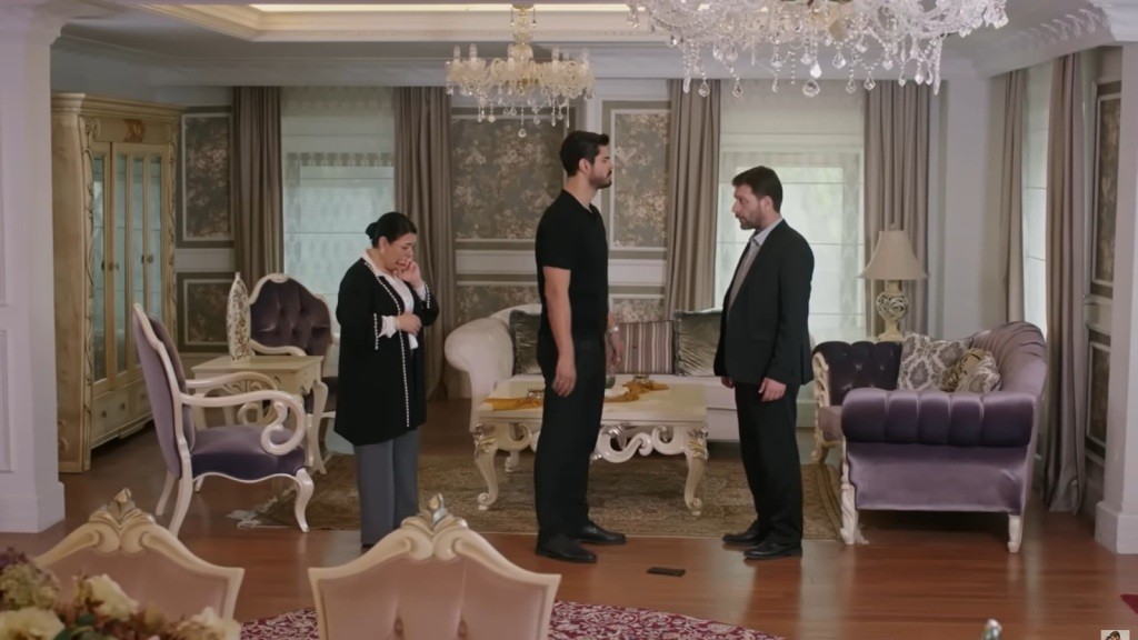 Scena w salonie. Cihan stoi naprzeciwko Nusreta. Za jego plecami stoi Mukadder, pochylając głowę. Na podłodze, między Cihanem a Nusretem, leży telefon.