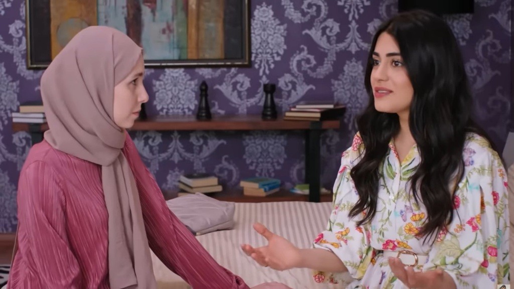 Sinem i Hancer rozmawiają, siedząc obok siebie na łóżku.