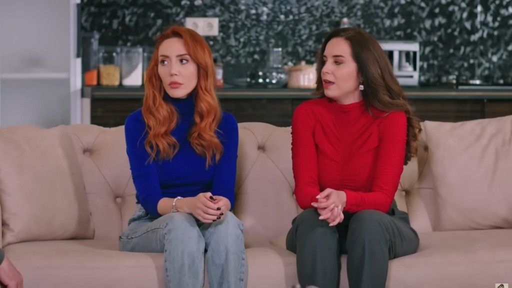 Yonca i Beyza siedzą obok siebie na kanapie.