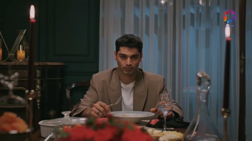 Sinan siedzi przy stole podczas kolacji.