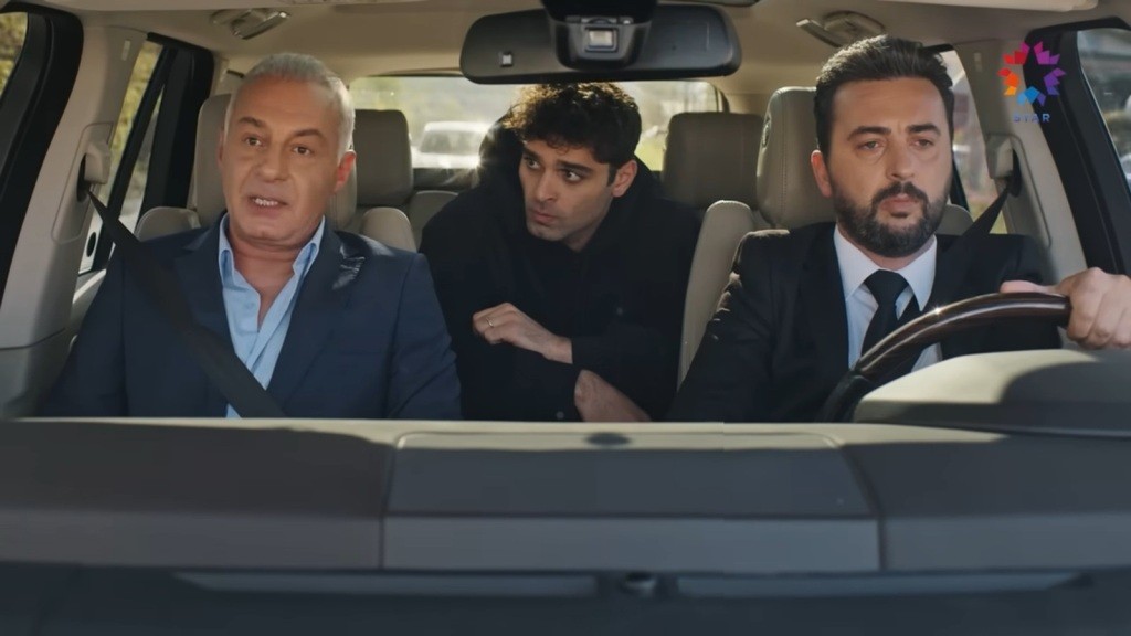 Osman prowadzi samochód. Na fotelu pasażera siedzi Mumtaz, a na tylnej kanapie Sinan.