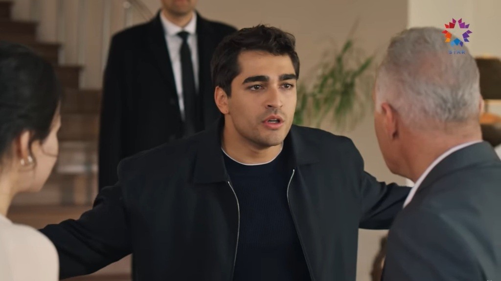 Ferit rozkłada ręce, stojąc przed Mumtazem.