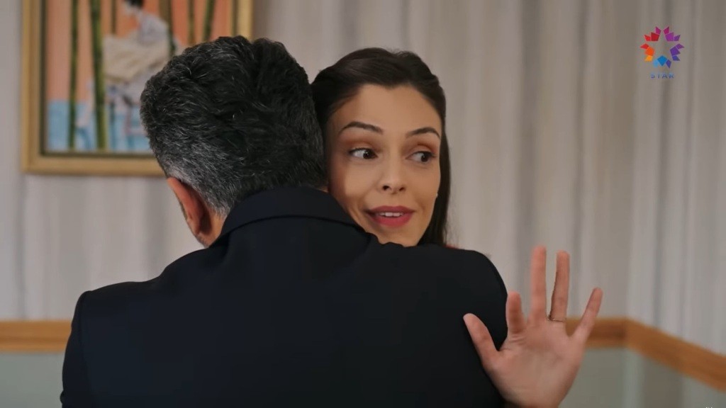 Betul, przytulona do Orhana, prostuje palce dłoni, jakby kogoś pozdrawiała.