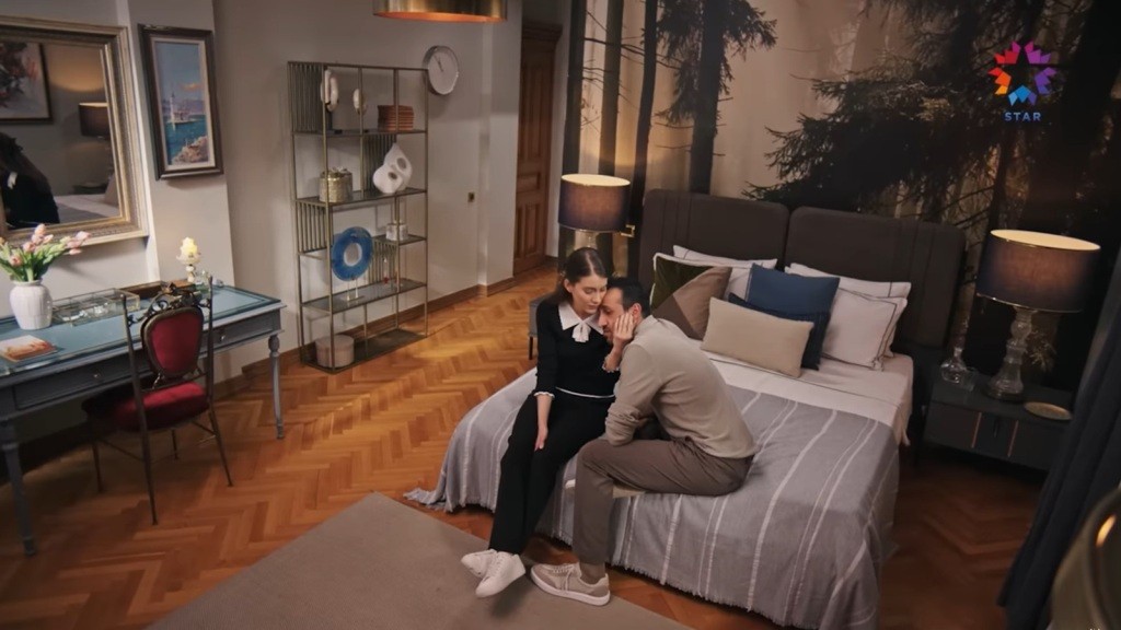 Suna i Abidin siedzą na skraju łóżka.