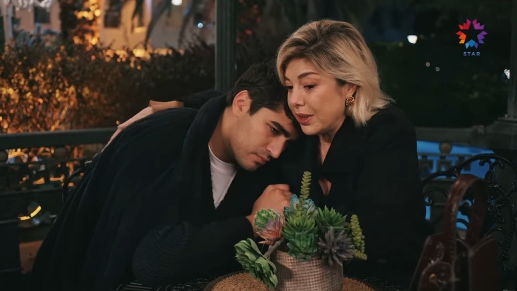 Gulgun obejmuje Ferita. Oboje siedzą w altanie.