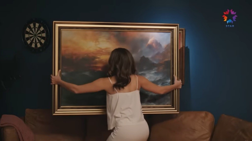 Seyran zdejmuje obraz ze ściany.