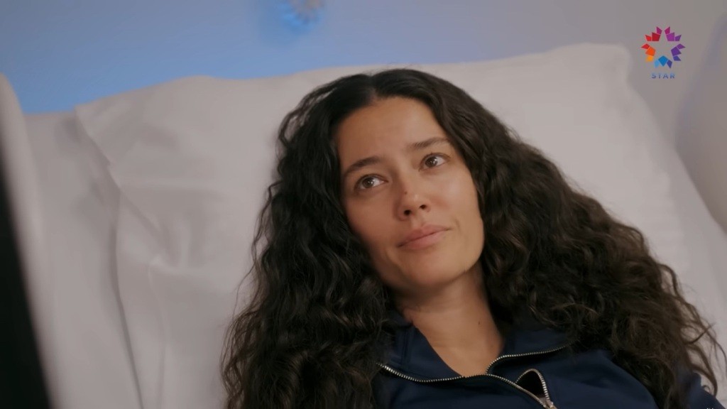 Diyar leży na łóżku szpitalnym.