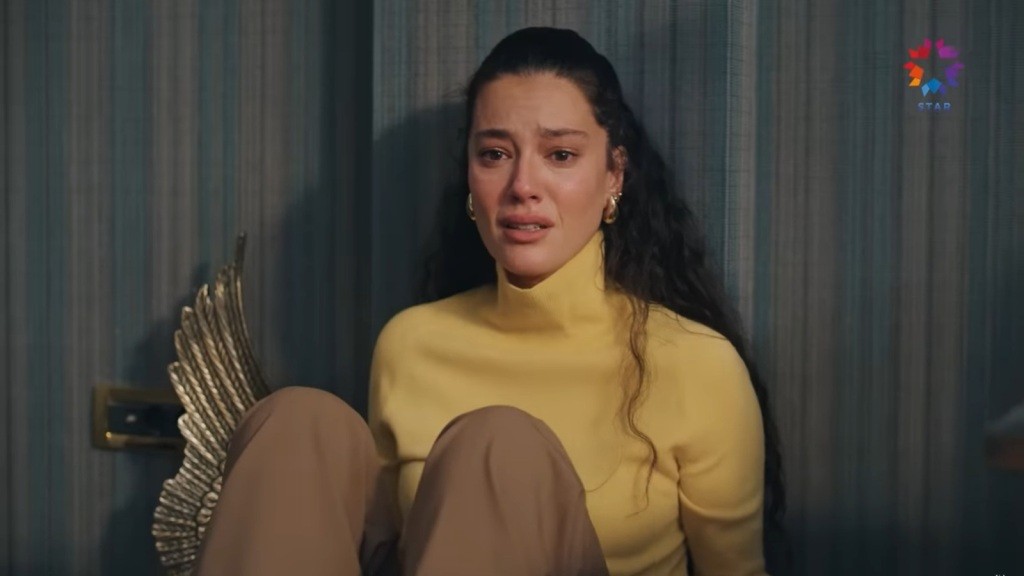 Diyar siedzi przy ścianie. Na jej twarzy maluje się rozpacz.