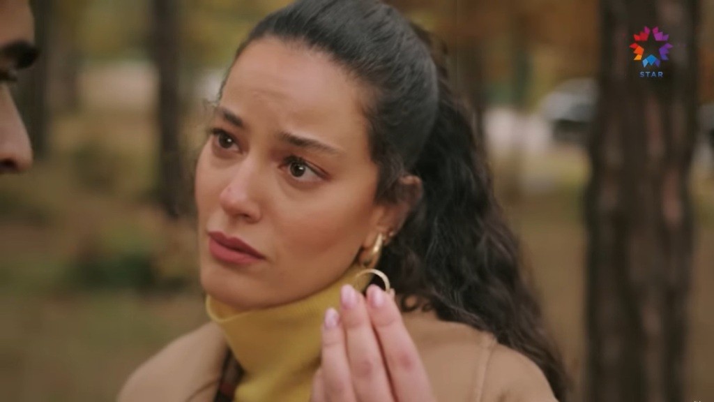 Diyar unosi rękę. W palcach trzyma obrączkę.