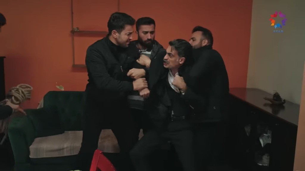 Trzech mężczyzn unieruchamia Kazima.