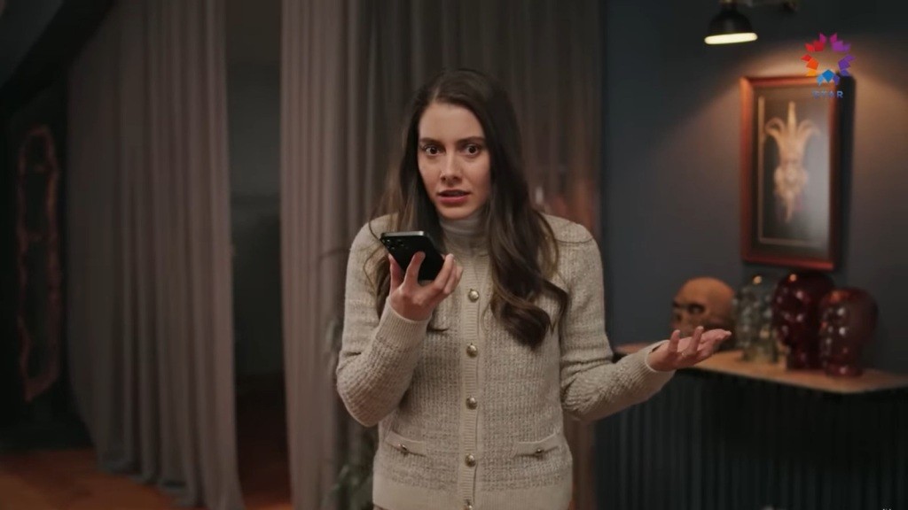 Suna trzyma telefon w ręku. Sprawia wrażenie poruszonej.