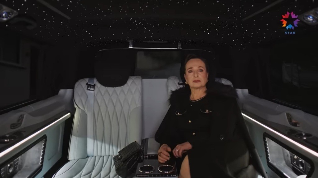 Elegancka kobieta w luksusowym wnętrzu limuzyny, otoczona tysięcem gwiazd stworzonego przez system oświetlenia. Wygląda na pewną siebie i zrelaksowaną, co podkreśla wyjątkową atmosferę tego miejsca.