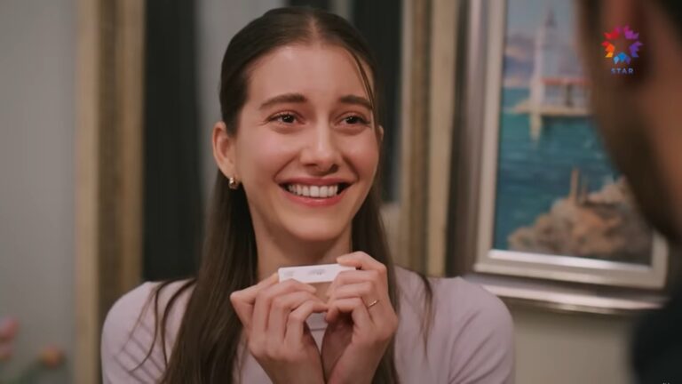 Suna trzyma test ciążowy w rękach. W okienku widać dwie kreski.