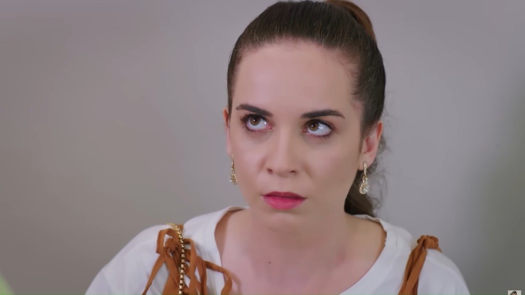 Beyza patrzy w górę z wyraźną irytacją.