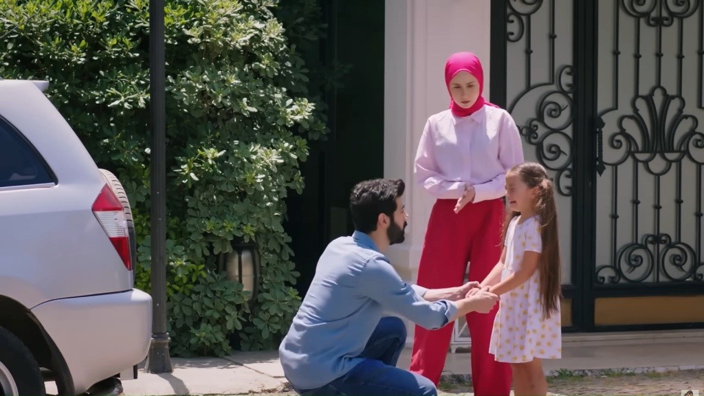 Melih kuca przed Mine i ujmuje jej ręce. Sinem stoi obok nich.