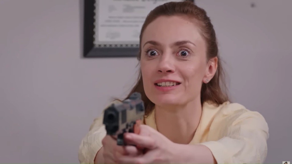 Derya pewnie trzyma pistolet, mierząc przed siebie.
