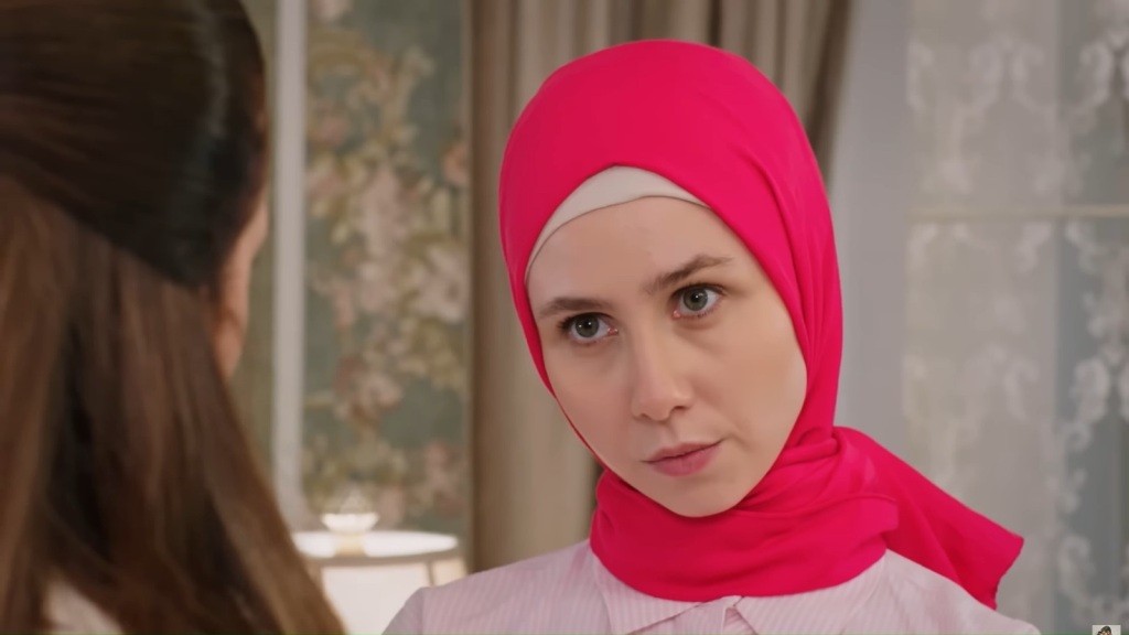 Sinem przechyla głowę, patrząc w oczy Beyzy.