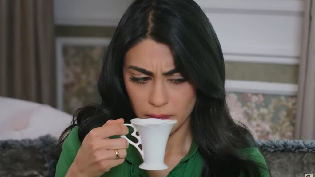 Hancer podnosi filiżankę do ust. Marszczy brwi.