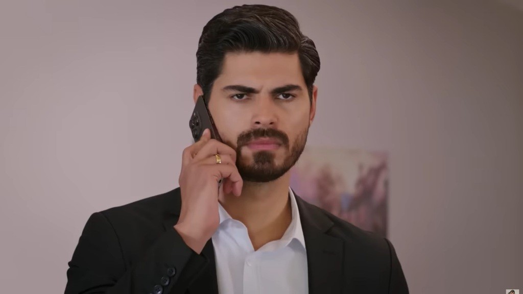 Cihan rozmawia przez telefon. Marszczy brwi.