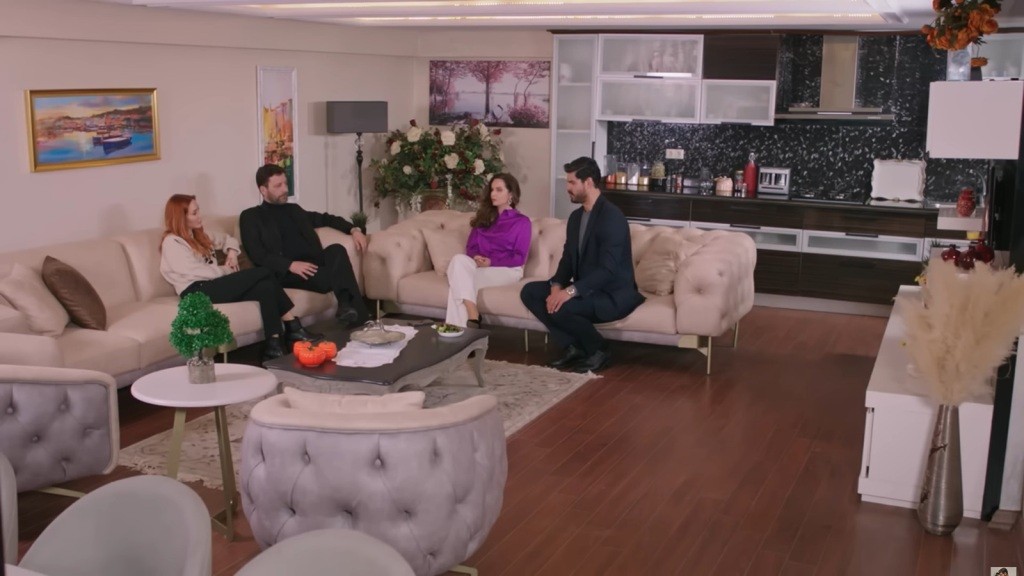 Salon w domu Nusreta. Nusret i Yonca siedzą na jednej kanapie, Beyza i Cihan na drogiej.