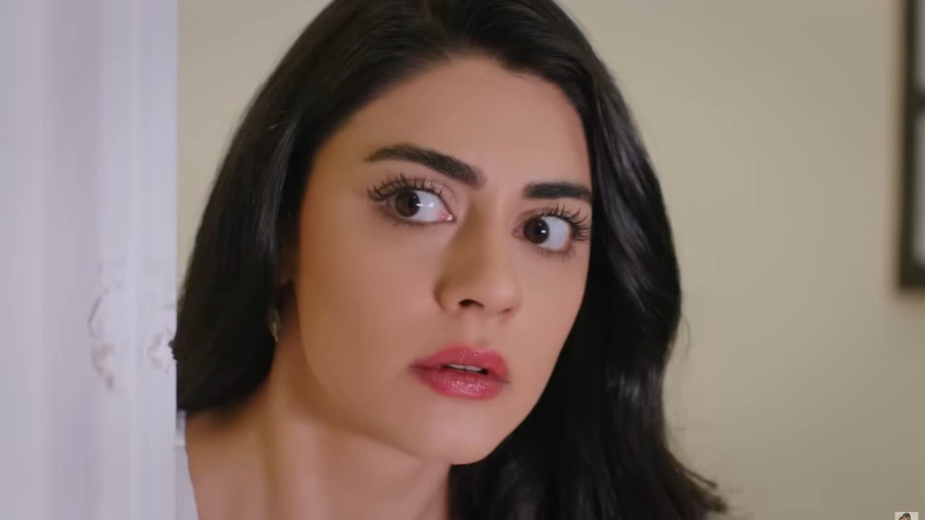 Hancer wygląda zza winkla. Sprawia wrażenie zszokowanej.