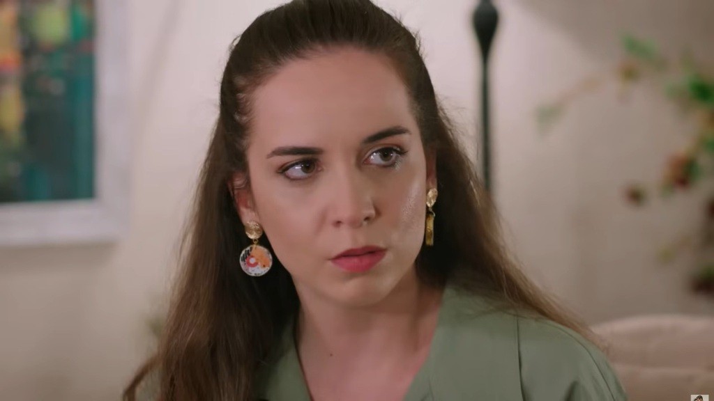 Na twarzy Beyzy maluje się lekkie napięcie. Przy jej uszach wiszą eleganckie kolczyki.