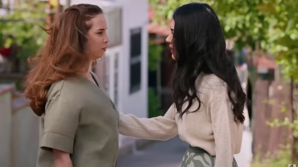 Hancer stoi naprzeciwko Beyzy i z troską dotyka jej ramienia.