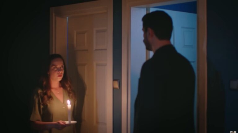 Beyza ze świecą w ręku stoi w progu naprzeciw Cihana — napięta, tajemnicza scena w półmroku.