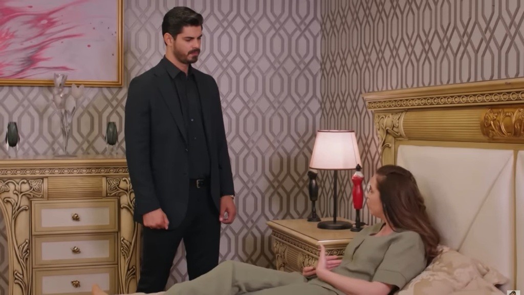 Cihan stoi przy leżącej na łóżku Beyzie.