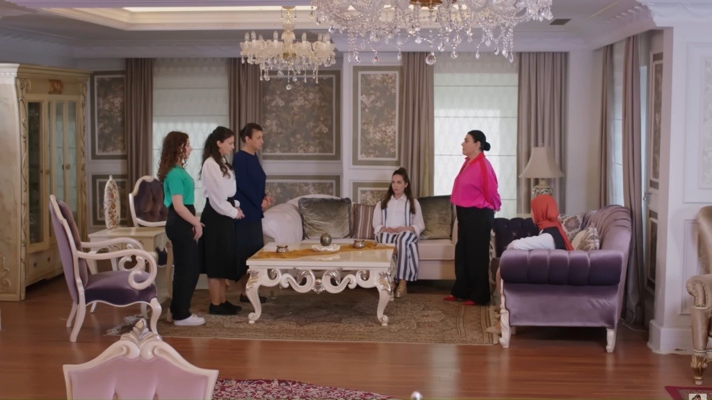 Scena w salonie. Pokojówki stoją przed Mukadder. Beyza i Sinem siedzą na kanapie.