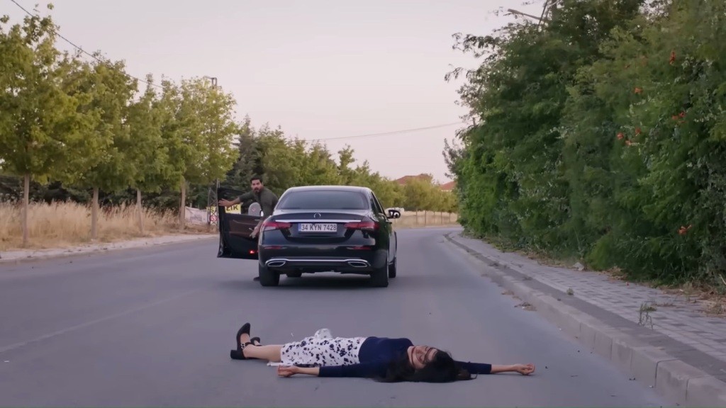 Cihan wysiada z samochodu. Hancer leży na asfalcie.