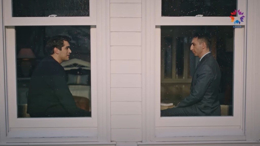 Ferit i Fuat siedzą naprzeciwko siebie na parapetach.
