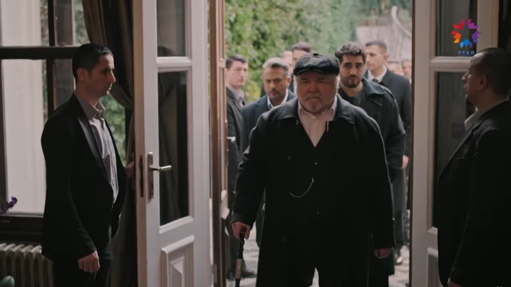 Halis przekracza próg posiadłości Wielkiej Damy. Za nim idą Orhan i Ferit oraz ochroniarze.