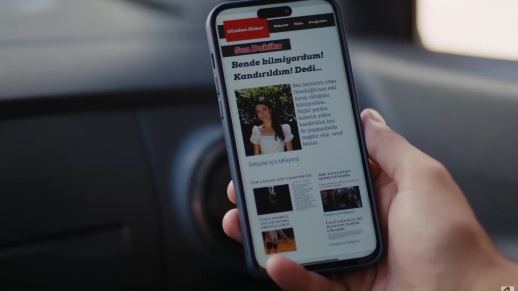 Zbliżenie na ekran telefonu. Wyświetlony jest portal plotkarski, a na jego stronie głównej zdjęcie Hancer i krzykliwy nagłówek.