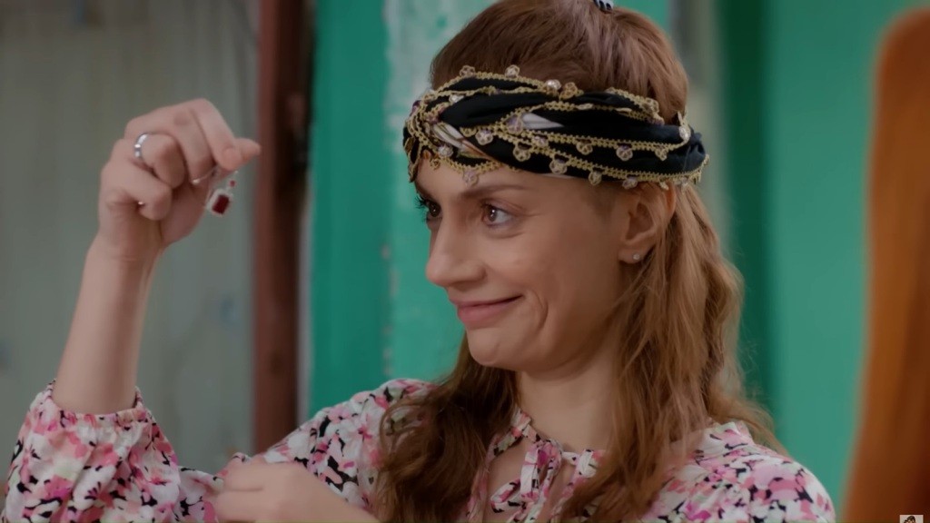 Derya z uśmiechem na twarzy ogląda wisiorek.