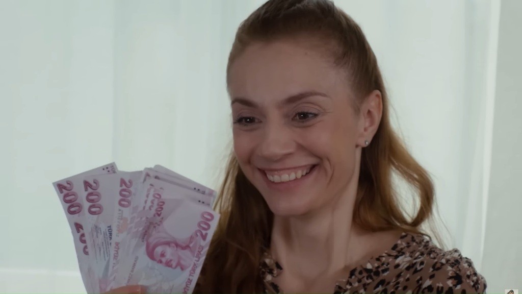 Derya w zachwycie ogląda plik banknotów, które ułożyła w wachlarz.