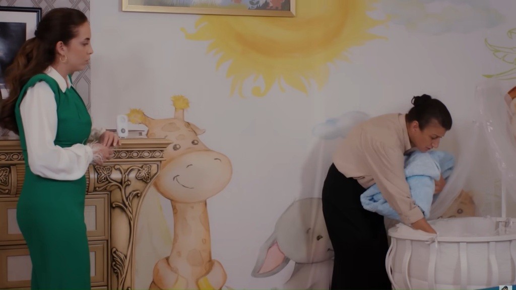 Fadime pochyla się nad łóżeczkiem dziecięcym. Beyza stoi obok.