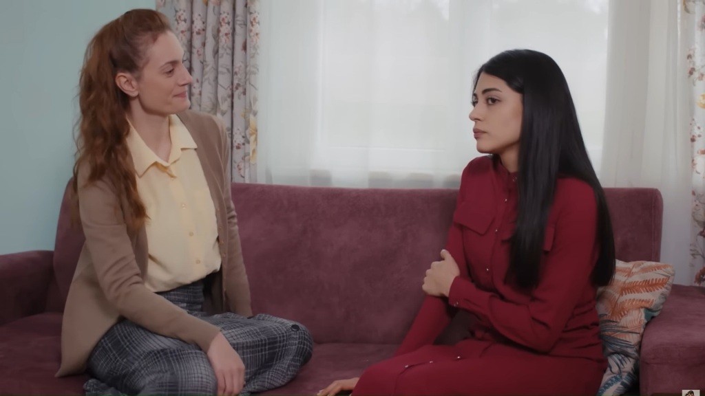 Derya i Hancer siedzą na kanapie.