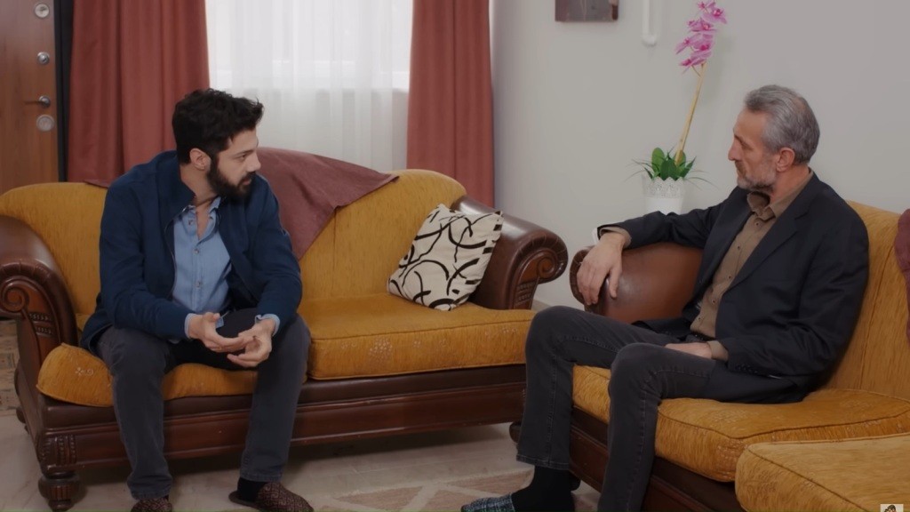 Melih i Mahmut siedzą na kanapach w przytulnym salonie.