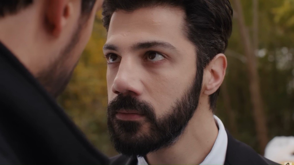 Melih podnosi wzrok, patrząc Cihanowi prosto w twarz. Jego twarz ma ostry wyraz.