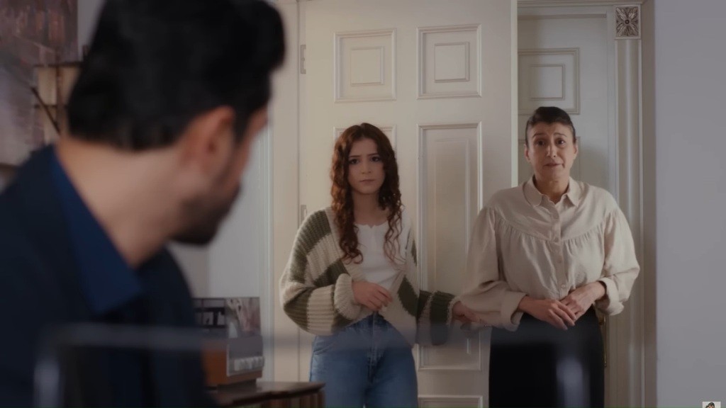 Cihan patrzy w stronę Aysu i Fadime stojących w progu drzwi. Kobiety mają niepewne wyrazy twarzy.