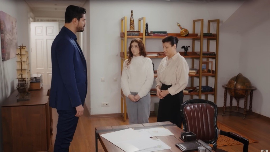 Fadime i Aysu stoją przed Cihanem z opuszczonymi głowami i splecionymi przed sobą dłońmi. Formalna, napięta atmosfera przy biurku.