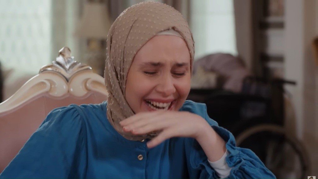 Sinem śmieje się do rozpuku. Unosi rękę, chcąc zasłonić dłonią usta.