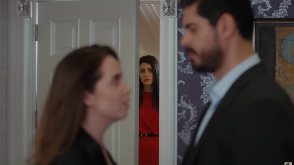 Beyza i Cihan stoją naprzeciwko siebie, patrząc sobie w oczy. Na drugim planie widać Hancer, która obserwuje ich przez uchylone drzwi.