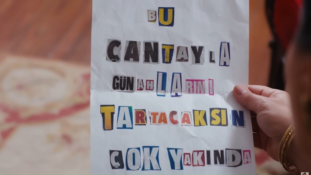 Zbliżenie na kartkę z wyciętymi literami ułożonymi w wiadomość.