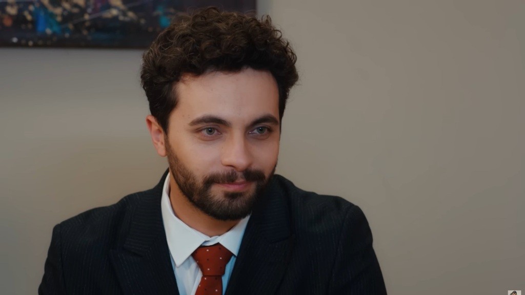Mężczyzna w formalnym stroju patrzy z empatią i spokojem.