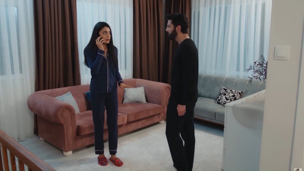 Hancer i Melih rozmawiają w salonie; ona trzyma telefon i wygląda na zdenerwowaną.